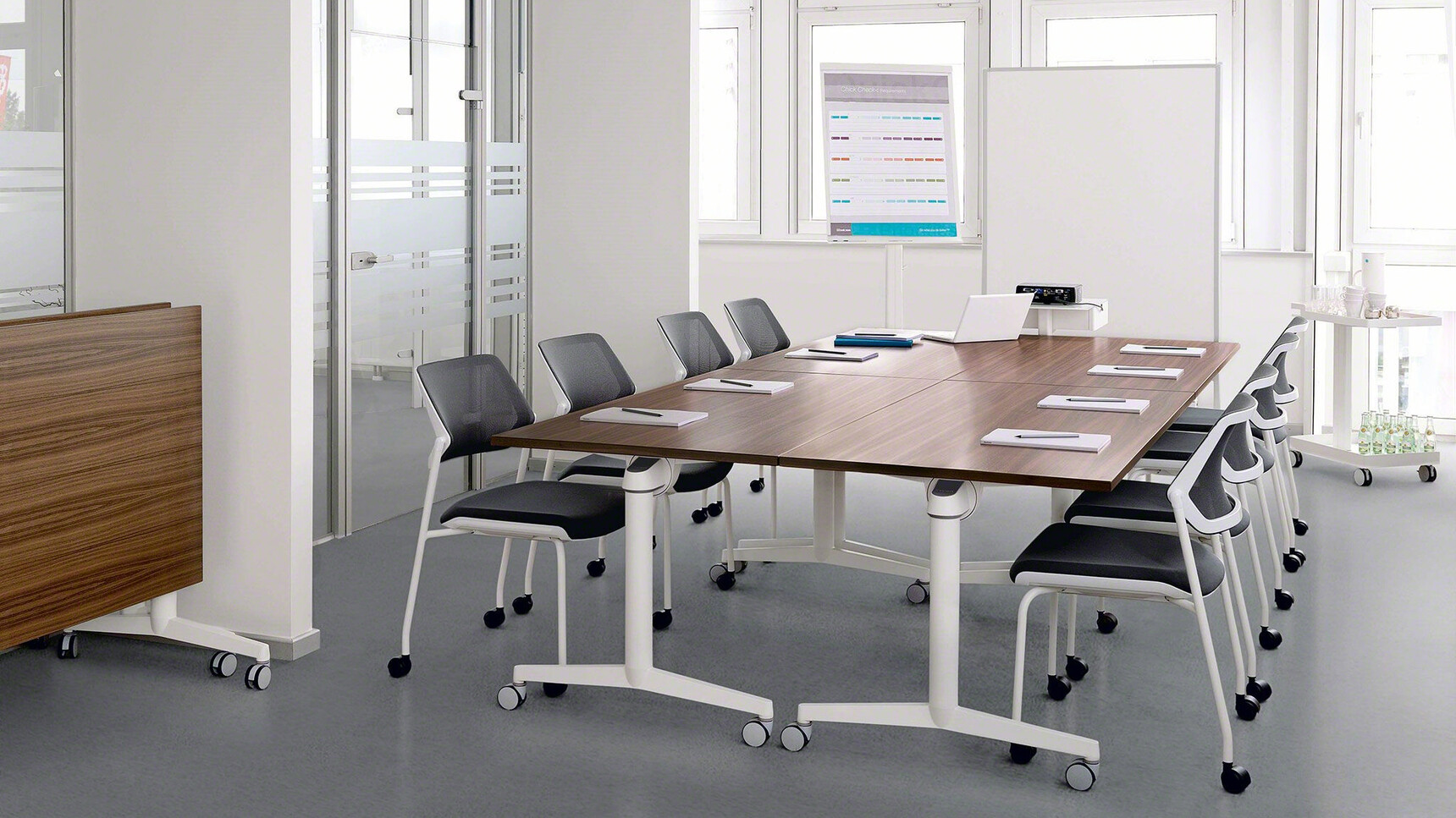 Two Steelcase Flip Top Twin Rectangular Meeting Tables With  White Aluminium Legs And Wood Finish With Eight Black Qivi Four Leg Base Conference Chairs on Castors In Meeting Room