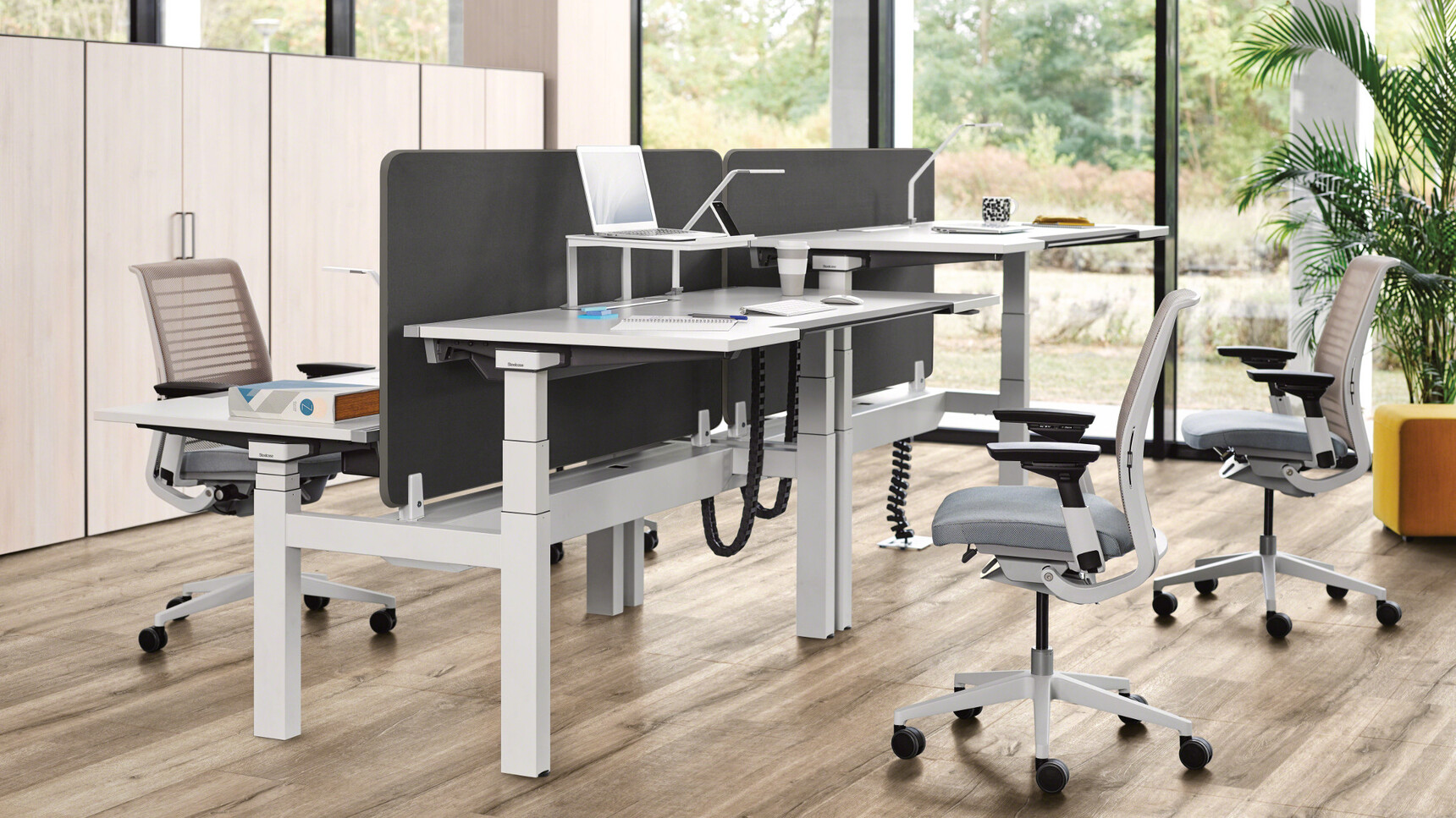 Two Steelcase Ology Height Adjustable Bench Desks with Active Touch Platinum Metallic White Leg White Top Grey Upholstered Four Think 3D Knit Back At Desk